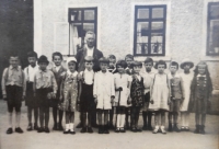 Školní fotografie před školou ve Ferdinandově – Inge stojí uprostřed v bílých podkolenkách s holí