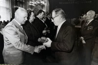 Manžel pamětnice přebírá gratulaci k vyznamenání Laureát státní ceny od Lubomíra Štrougala, 1983