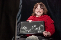 Libuše Vrtišková Hájková ve studiu v roce 2024 se svou fotografií z Václavského náměstí během sametové revoluce v roce 1989