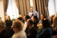 Milan Panoch (vzadu sedící s nasazenými brýlemi zcela vpravo) na fotografii z veřejné debaty k přesunutí sochy rudoarmějce z centra Pardubic. Pamětník se léta občansky zasazuje o přesunutí této sochy, protože pro něj představuje sféru ruského vlivu.