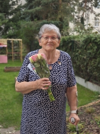 Sylva Puchingerová na dvorku s kyticí jako poděkováním za natáčení pro Paměť národa, 17. dubna 2025