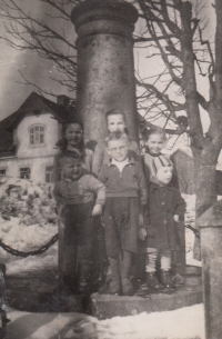 Devítiletá Anna Plobner (vlevo) s oběma sourozenci a dětmi sousedů před Böttgerovým pomníkem v centru Pavlova Studence, pravděpodobně v roce 1941