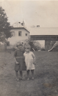 Sestra Berta a asi tříletá Anna na Šancích, v pozadí dům a statek prarodičů z otcovy strany, pravděpodobně v roce 1935
