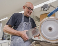 Pamětník při práci na broušení skleněné plastiky