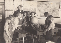 Paní učitelka Čejková v roce 1954 se svými žáky ve škole v Jičíněvsi. Pamětnice se sklání nad glóbem 