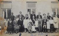 The second wedding of Karel's father in front of his pub, Karel is sitting on a stool in the front, to the left, 1933