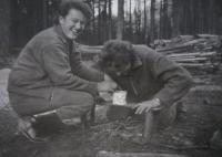 Miloslava (on the left) warms up her snack during work in the forest