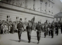 Slavnostní defilé. Jan Ihnatík uprostřed se zástavou
