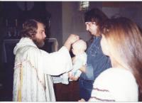 Priest Vojtěch baptizes a child
