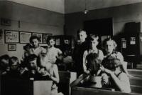Fotografie Walterovy třídy, obecná škola v Horních Heršpicích, Walter v bílém triku s límečkem jí chléb, Horní Heršpice, 1939