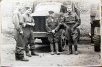 soldiers standing next to Studebacker cars