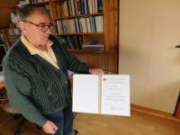 Miloslav Šváček s diplomem k udělení pamětní medaile České biskupské konference