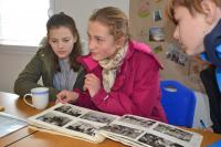 Pupils from the project Stories of Our Neigbours are looking at photo album