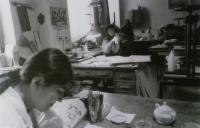 Osazenstvo dílny na nábřeží 2, pamětnice u stolu uprostřed, 80. léta 